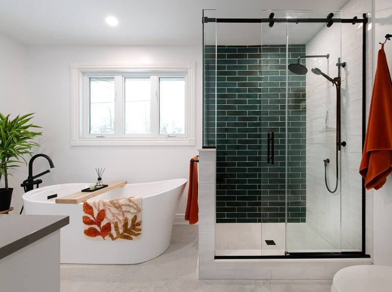 Modern bathroom renovation with green tile and freestanding tub