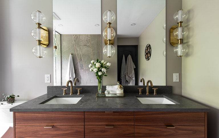 Main bathroom renovation - dark walnut vanity with champange bronze fixtures and gold sconces.